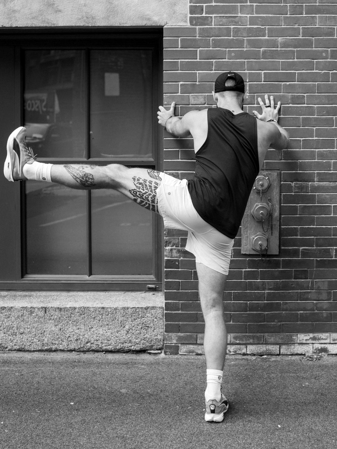Athlete stretching against a wall