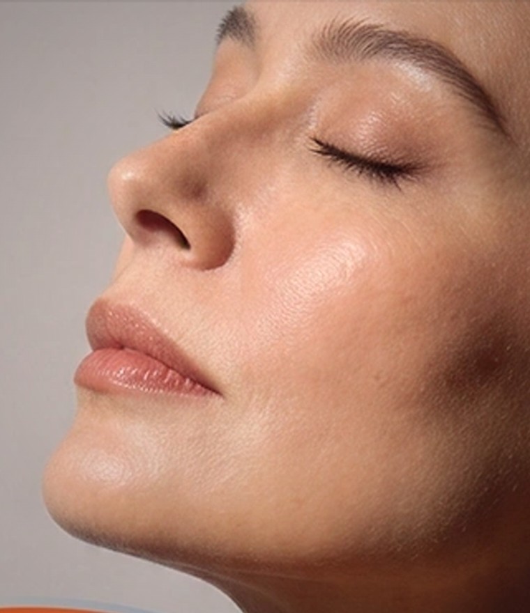 A woman receiving light-based skin rejuvenation, eyes closed