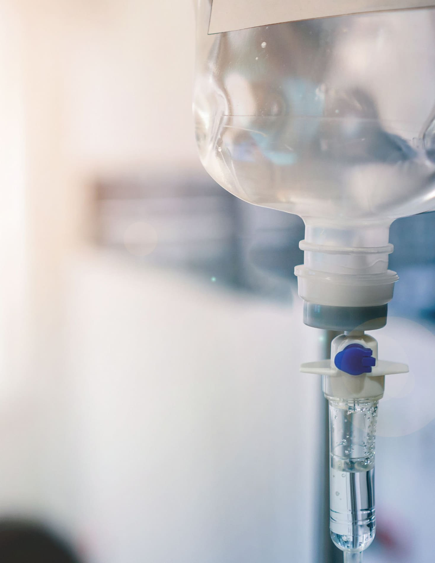 A close-up of an IV drip connected to a clear tube with flowing liquid, mounted on a metal stand.